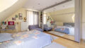 Urige Schrägen, bodentiefe Fenster und ganz viel Wärme: in diesem Schlafzimmer sind schöne Träume garantiert. 