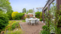 Die stilvolle Terrasse am Wintergarten bietet Raum für gesellige Abende und entspannte Stunden im Garten.