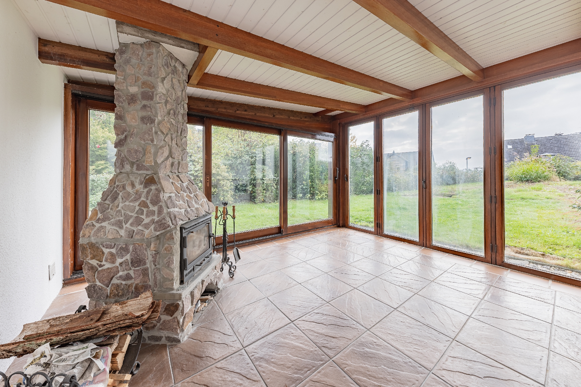 Wintergarten mit grüner Aussicht und Kamin