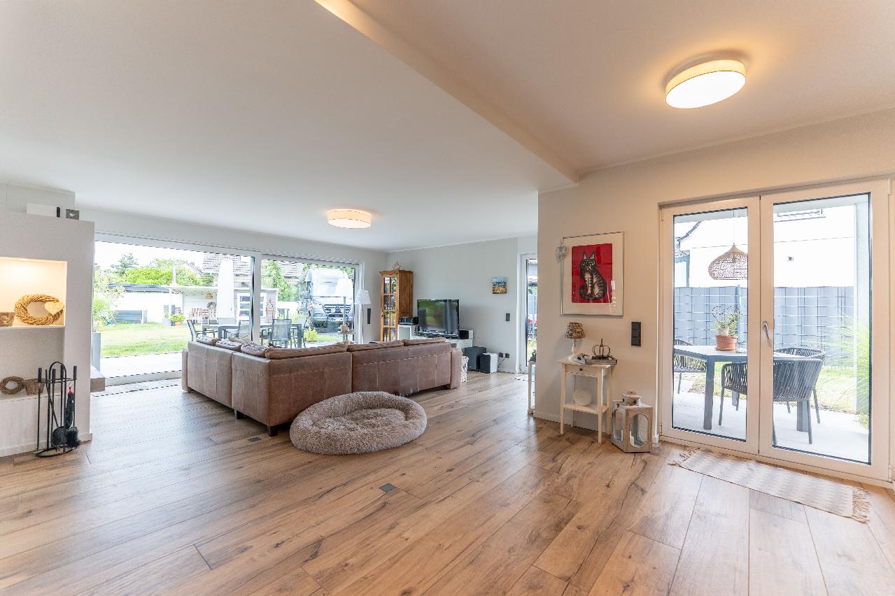 Lichtdurchfluteter Wohnbereich mit Kamin und diversen Zugängen zum liebevoll ang